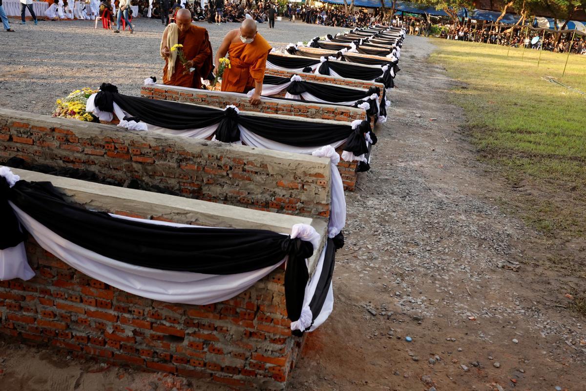 La gente observa cómo las piras funerarias incineran a 19 víctimas del tiroteo en la guardería de Uthai Suwan en el templo Wat Rat Samakee en Uthai Sawan. Un exoficial de policía disparó y mató a 37 personas, al menos 24 de ellos niños, después de irrumpir en una guardería infantil en el noreste de Tailandia.