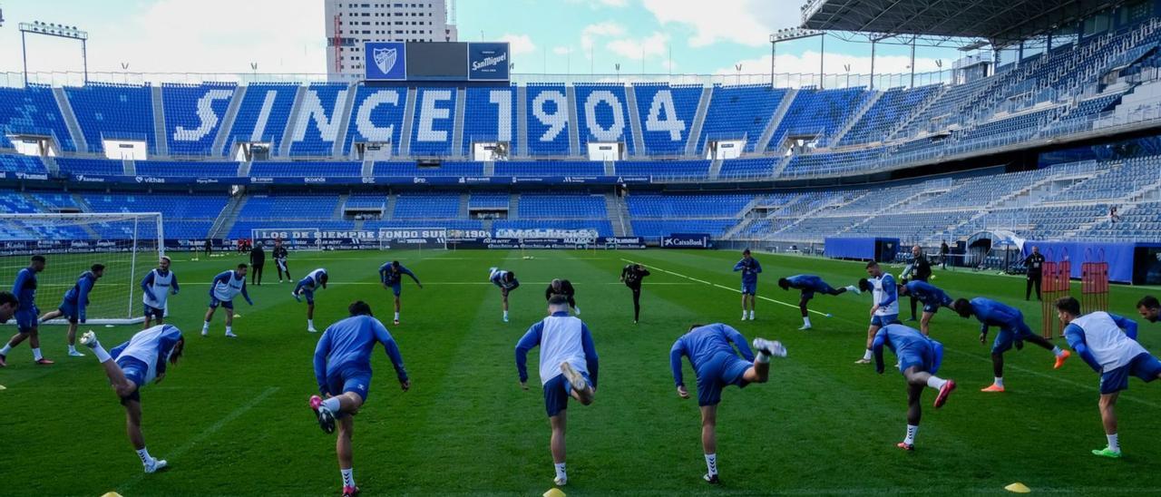 Los jugadores del Málaga se ejercitan sobre el césped de La Rosaleda.