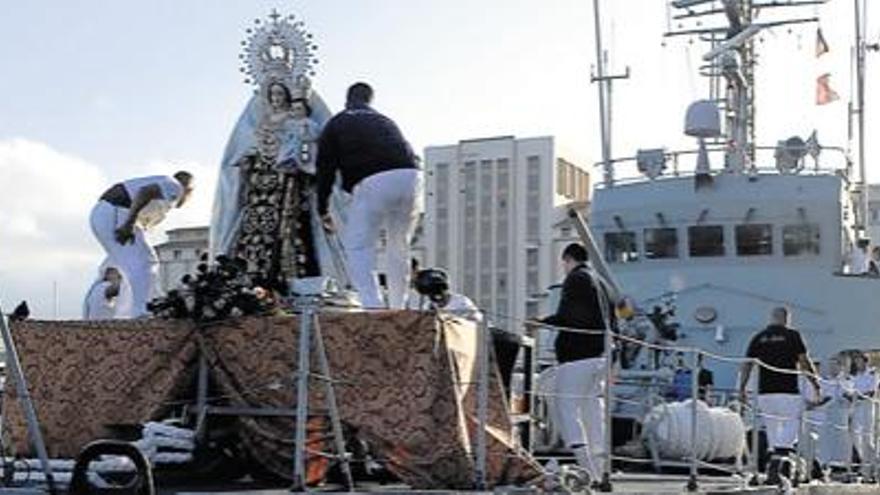 Los marineros preparan a la Virgen para su excursión marítima por la bahía de la capital, ayer por la tarde. i
