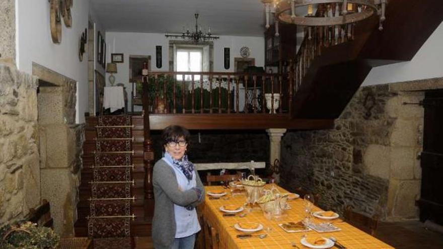 A la izquierda, Carmen Rey muestra parte de un suculento cocido en la cocina de Amarelle. Arriba, una imagen de la casa. // Bernabé/J. Lalín