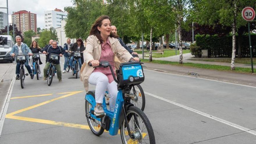 Inés Rey, en un acto de campaña en Elviña, con una bicicleta de Bicicoruña, acompañada por militantes del PSOE.   | // CASTELEIRO/ROLLER AGENCIA
