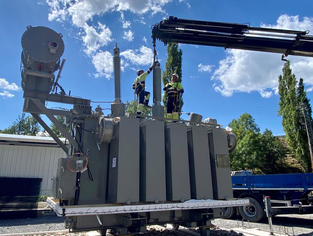 Dos operarios, durante el montaje de un transformador eléctrico en Biescas.