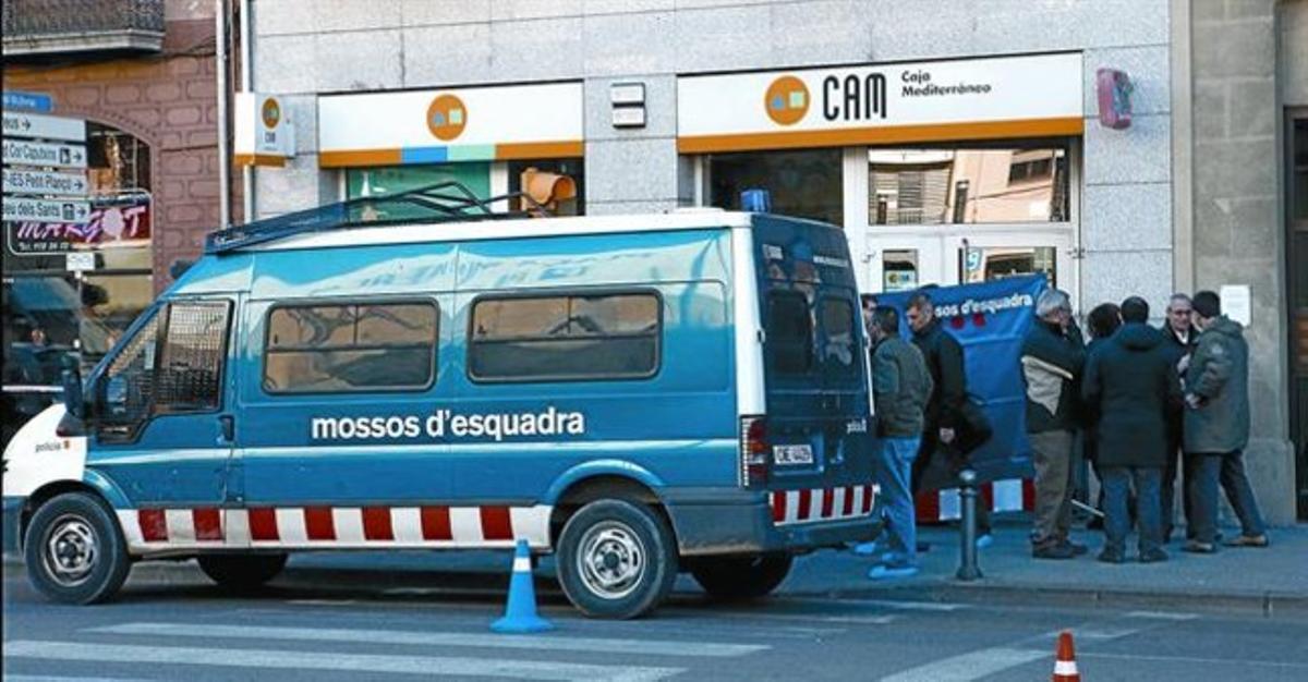 Agents dels mossos, ahir, davant de l’oficina bancària d’Olot on es va cometre un dels assassinats. Agents dels mossos, ahir, davant de l’oficina bancària d’Olot on es va cometre un dels assassinats.