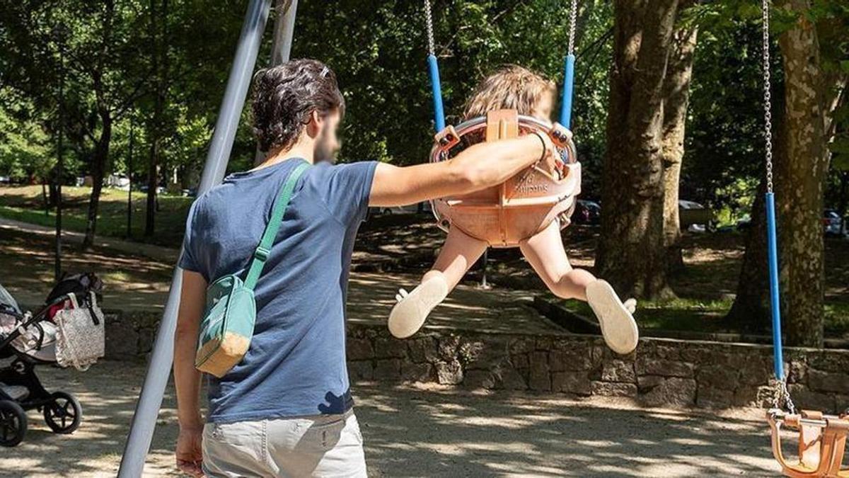 Un padre empuja a su hija en el columpio.