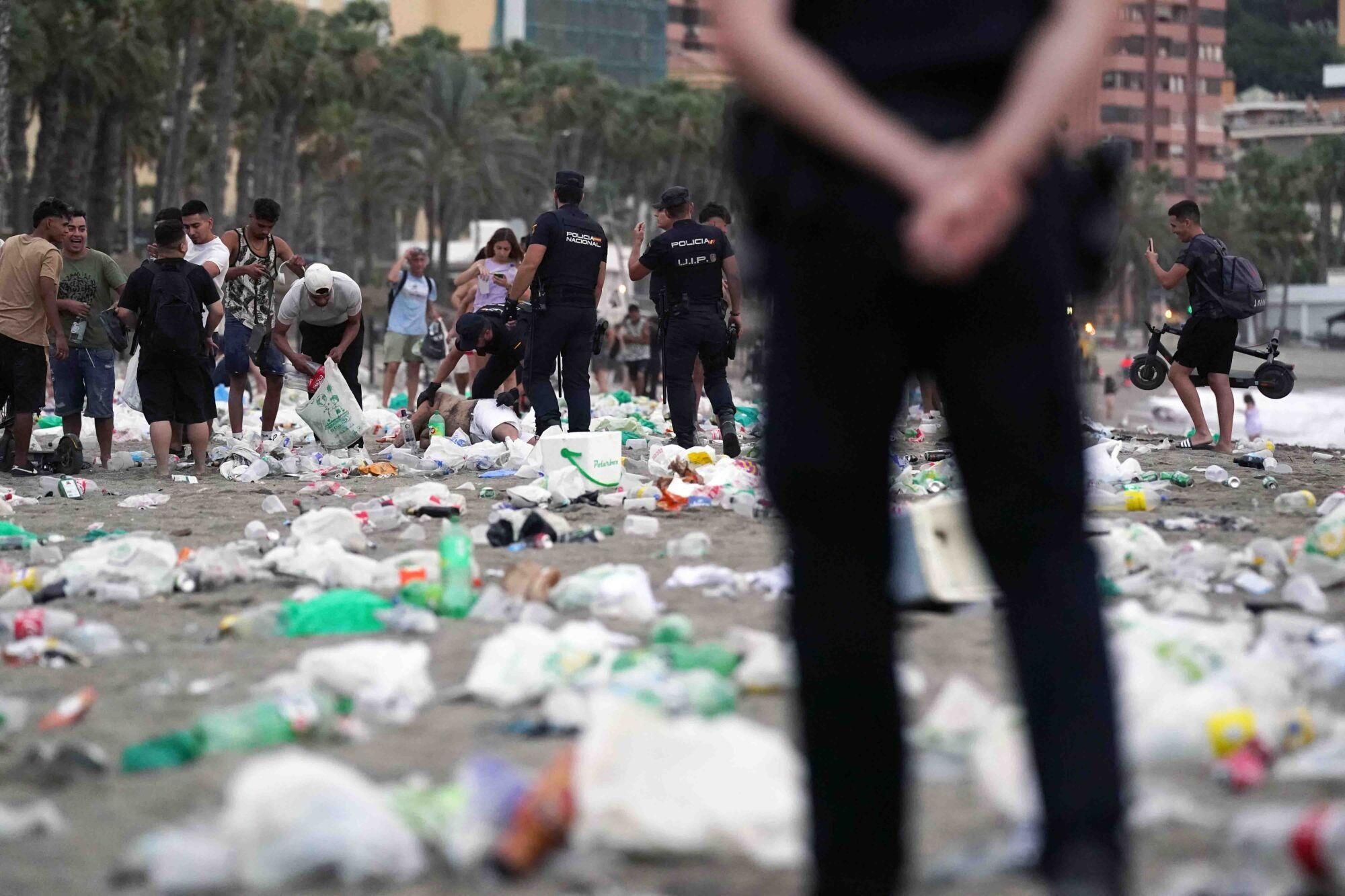 Varios operarios de la empresa de limpieza de Limasam, recogen los residuos de la playa de La Malagueta, tras la Noche de San Juan en Málaga 2025