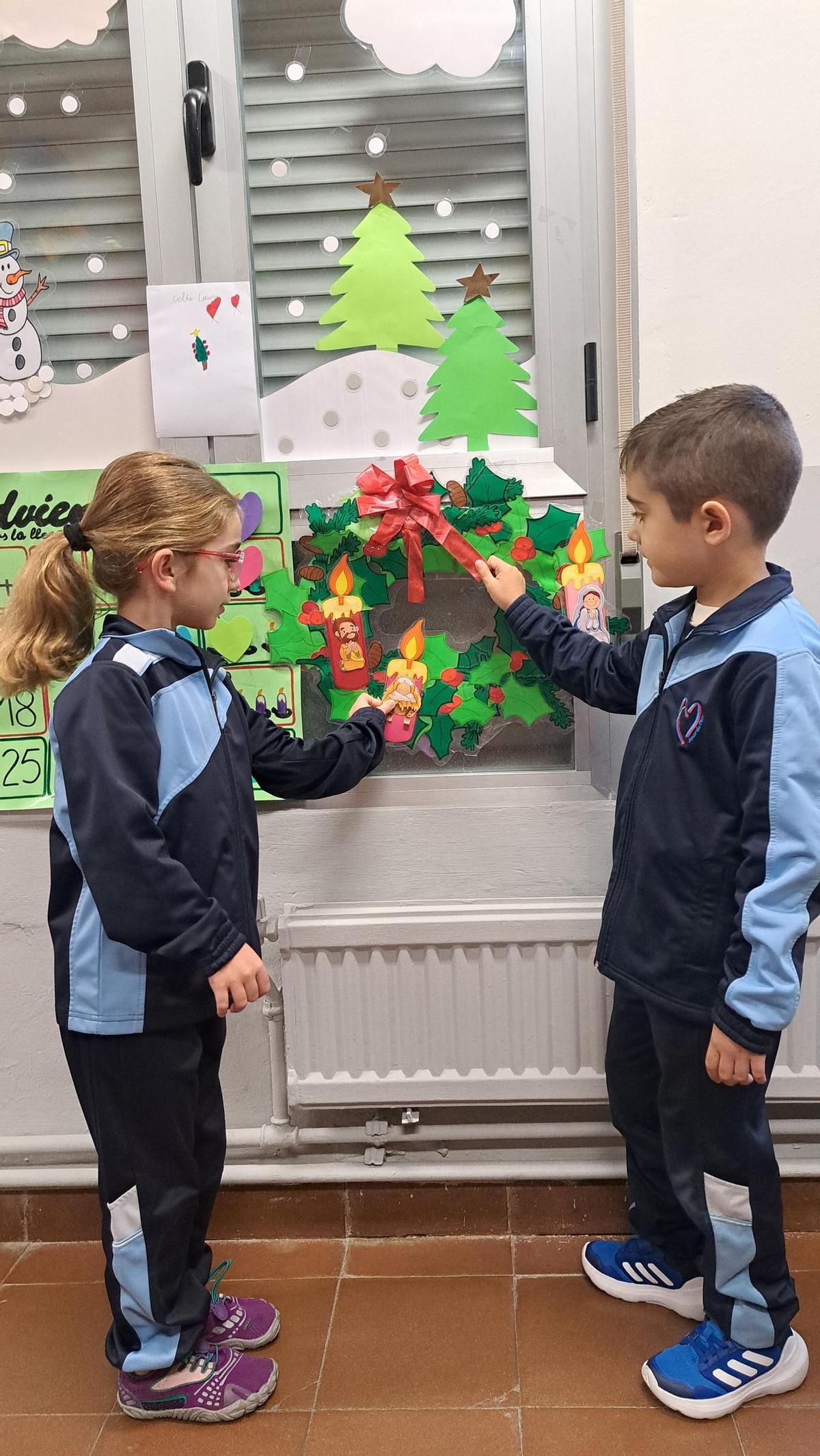 Dos estudiantes del colegio Nuestra Señora del Rocío colocan algunos adornos.