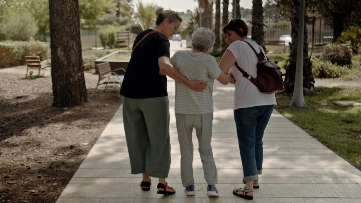 Joaquina Sánchez, enferma de alzhéimer a quien denegaron la primera solicitud de eutanasia, con sus hijas. Es un fotograma del documental 'La decisión de Joaquina'