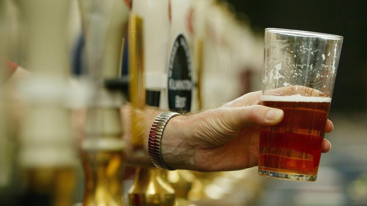 Un camarero sirve un vaso de cerveza entre varios tiradores.