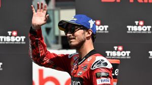 Bagnaia saluda al público durante un GP