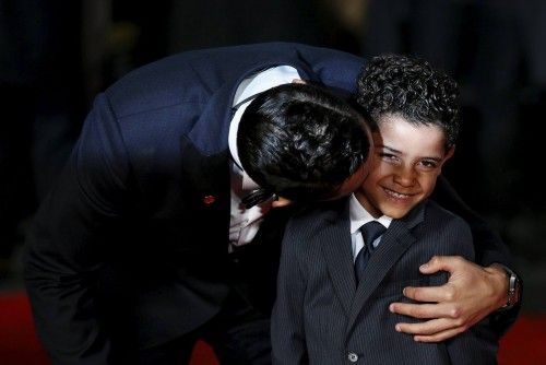 Soccer player Ronaldo kisses his son on the red carpet at the world premiere of "Ronaldo" at Leicester Square in London