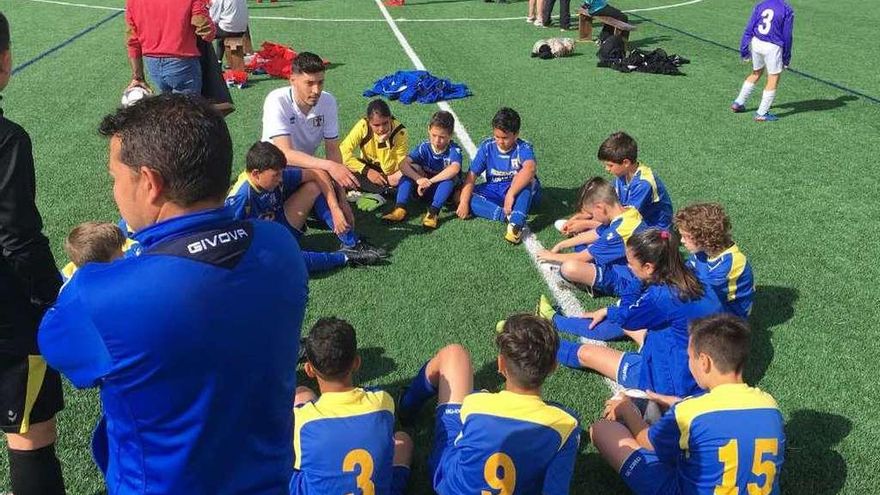 Varios chavales escuchan la charla de su entrenador.