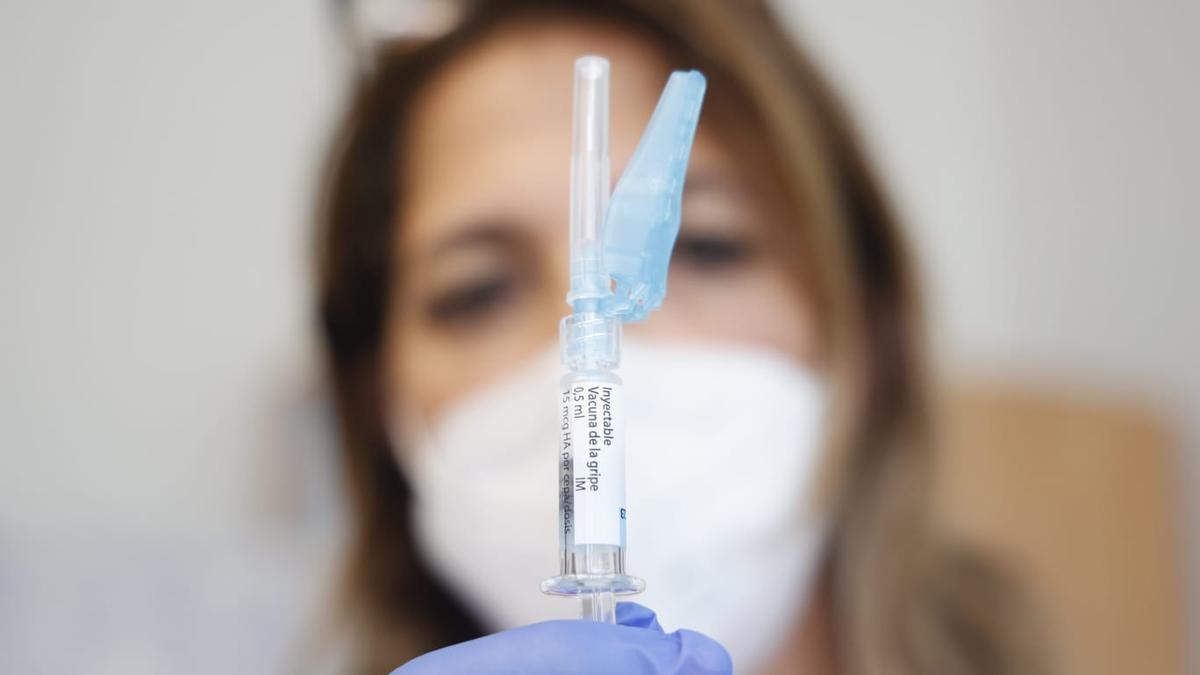 Una sanitaria sostiene un vial de la vacuna de la gripe mejorada.