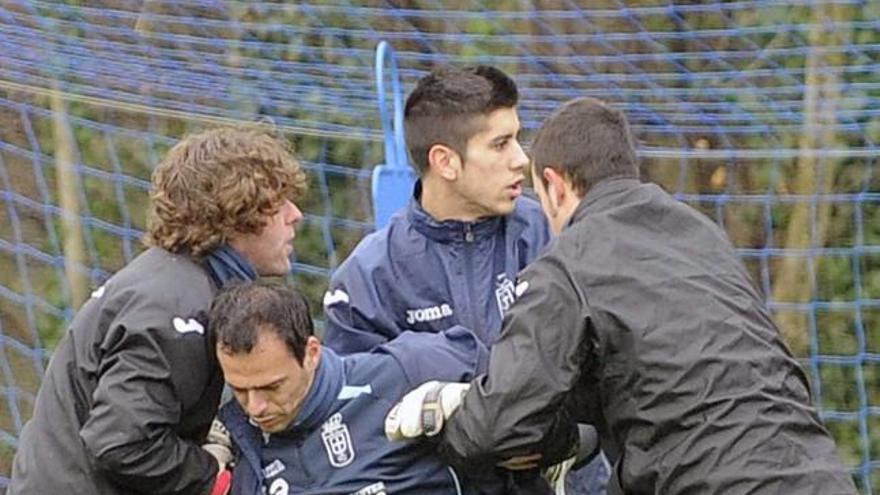 Diego Tuero, a la izquierda, y Dani Barrio, detrás, ayudan a un dolorido Orlando Quintana a salir del campo tras lesionarse, ayer, en El Requexón.