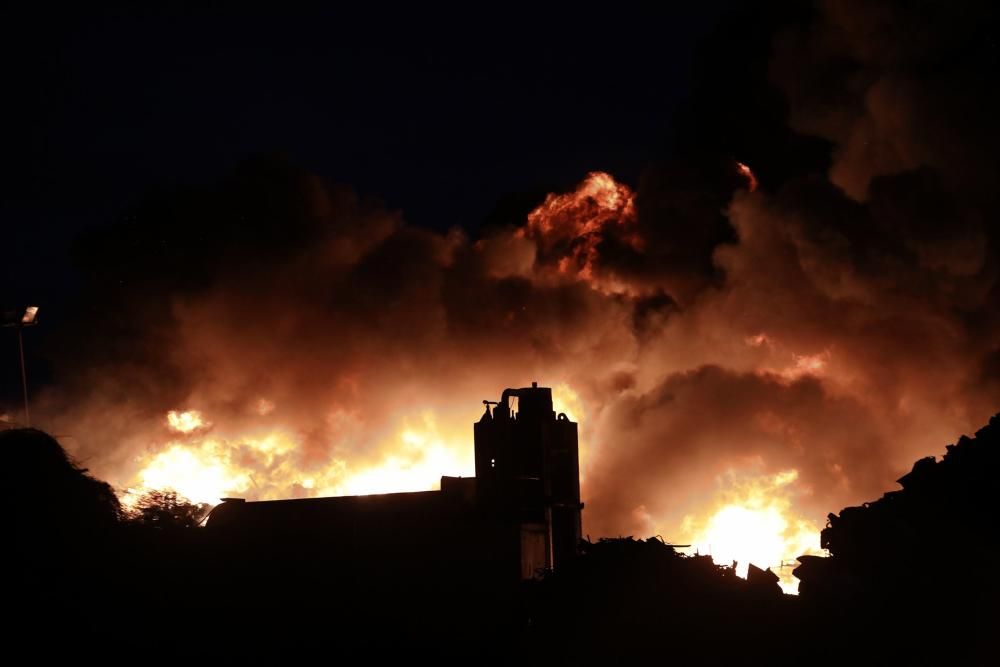 Labores de extinción del incendio de un desguace en Gijón