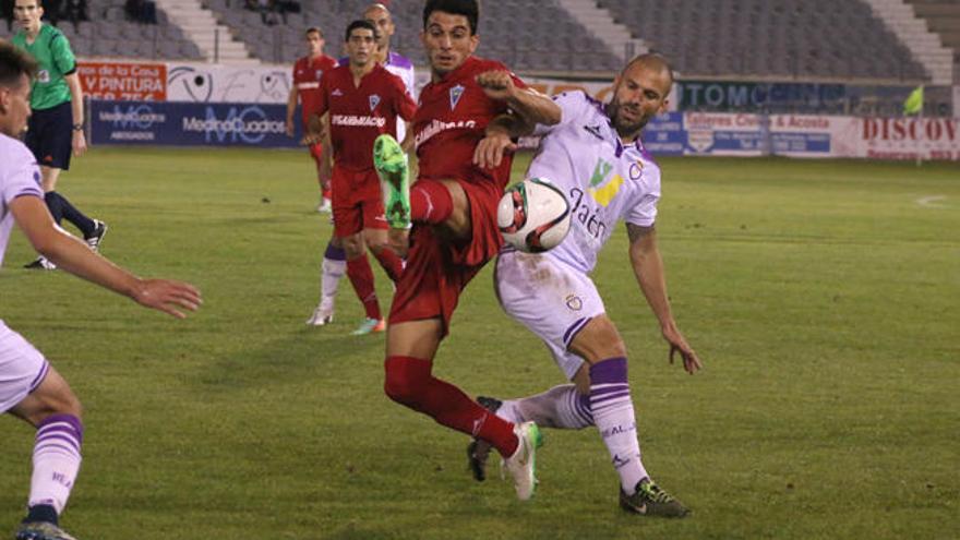 Álex Herrera levanta la pierna para intentar arrebatarle el esférico a un jugador del Jaén.