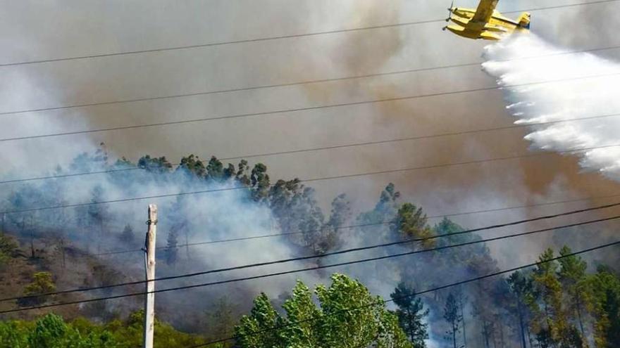 Vecinos de Rianxo contemplan el avance de las llamas, anoche, cerca de sus casas. // M.Méndez