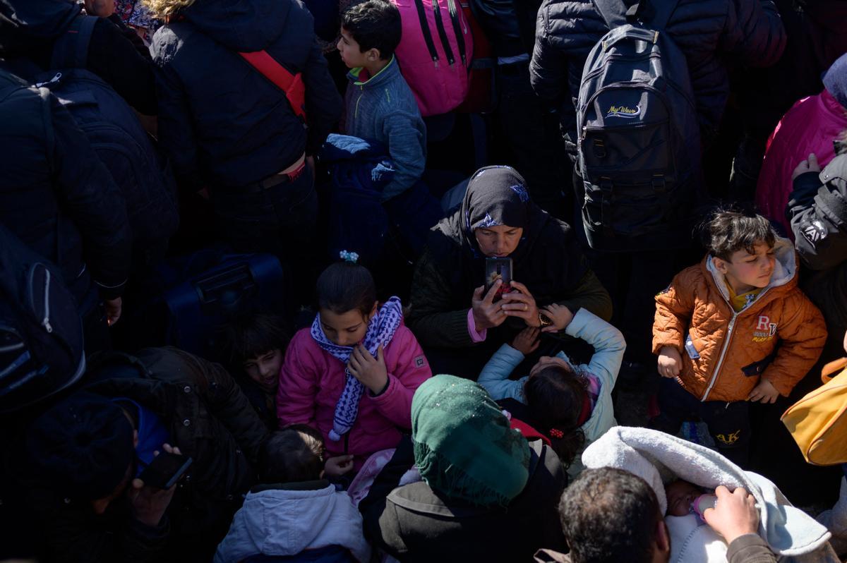 Los residentes sirios de la ciudad de Hatay esperan para cruzar la frontera entre Turquía y Siria después de que se vieron afectados por el terremoto de magnitud 7,8 que asoló la región hace casi dos semanas, en la puerta fronteriza de Cilvegozu