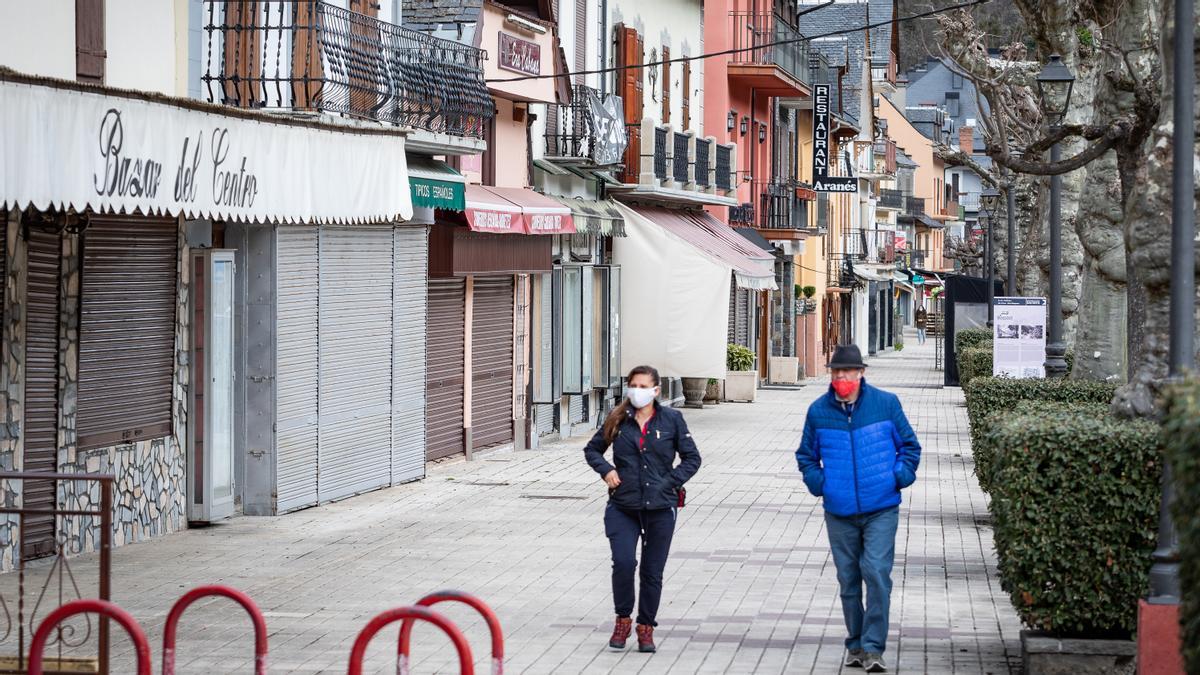 Poble de Bossost - Baish Aran, 2021/03/18; persones caminen pel carrer principal amb establimients tancats   foto: Gorka Martinez Llurda