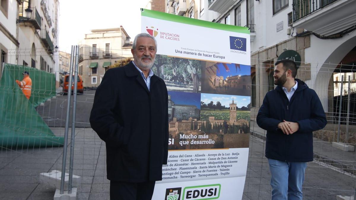 Carlos Carlos y Luis Salaya, esta mañana ante el cartel de anuncio de la obra en Cáceres.