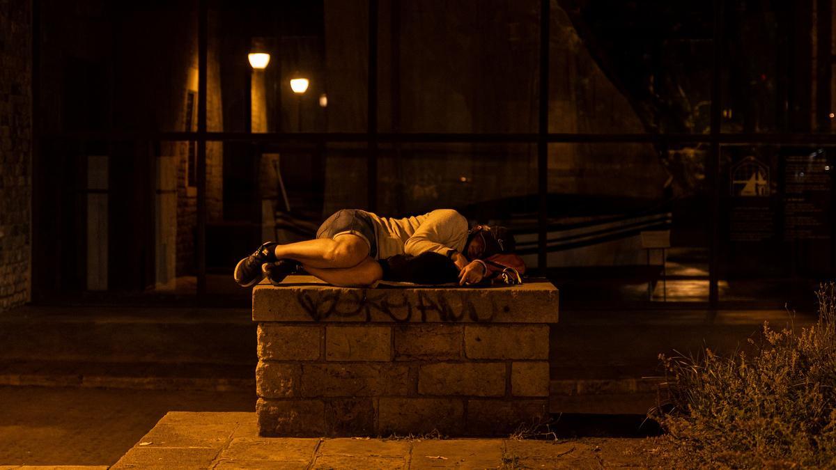 Una persona sin hogar duerme en los alrededores del Museo Marítimo