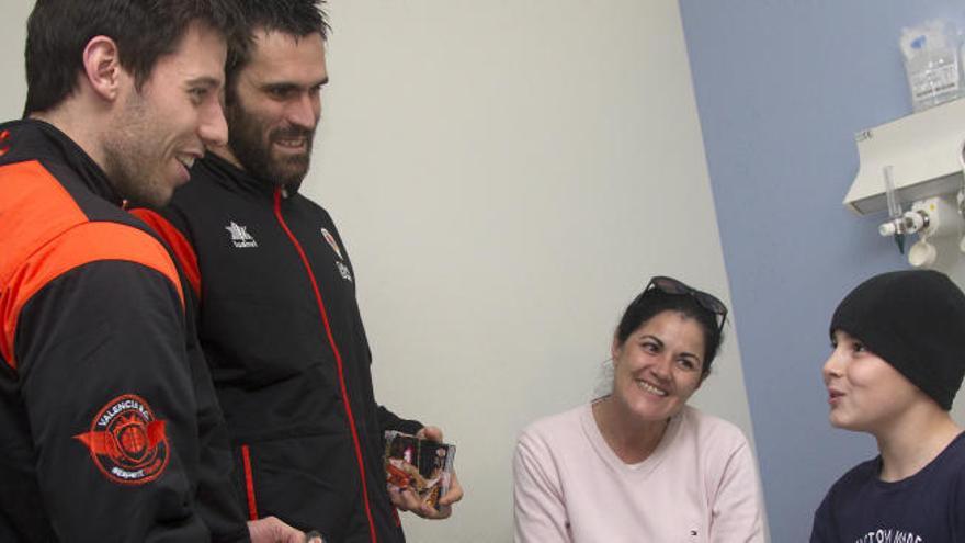 Van Rossom y San Emeterio dando un regalo a uno de los niños hospitalizados.