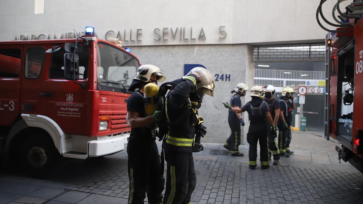 Bomberos apagando el fuego en el párking.