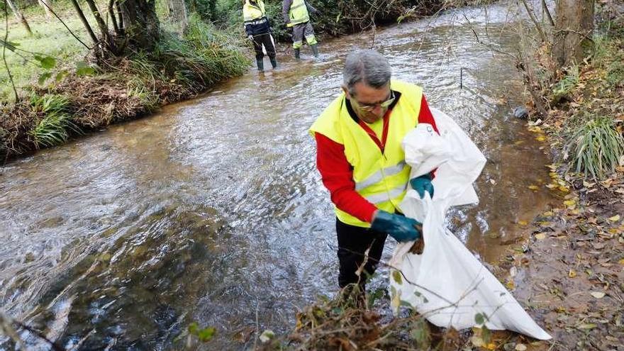 Tres de los voluntarios que ayer limpiaron el cauce del río Magdalena.