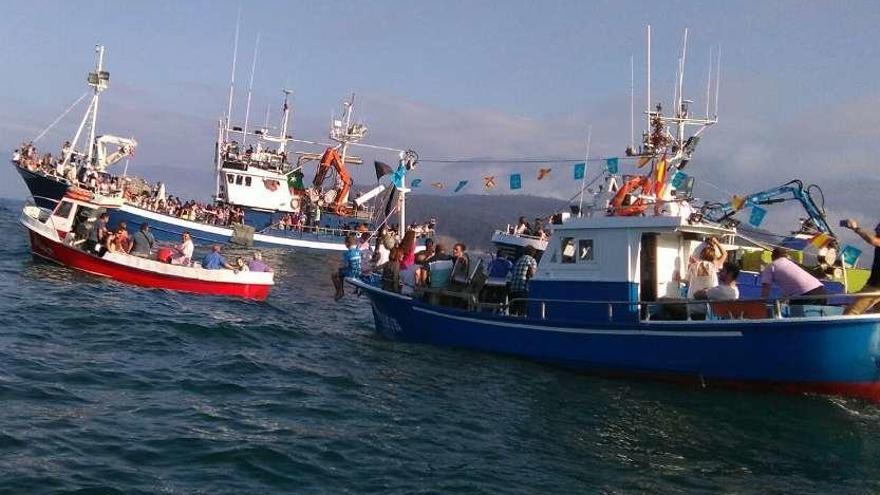 Arriba, los barcos en la procesión por el mar del año pasado en Lastres. Abajo, actuación de un grupo folclórico en la fiesta llastrina.