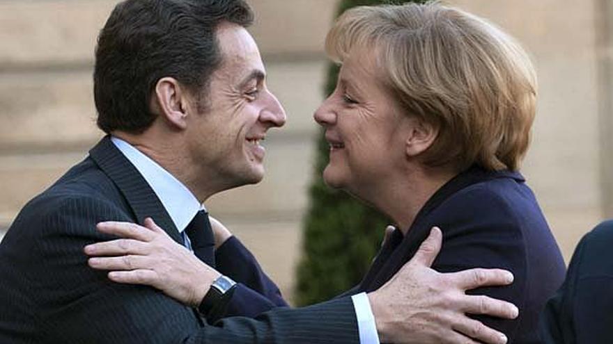 Sarkozy y Merkel se saludan al comienzo del X Consejo de Ministros franco-alemán