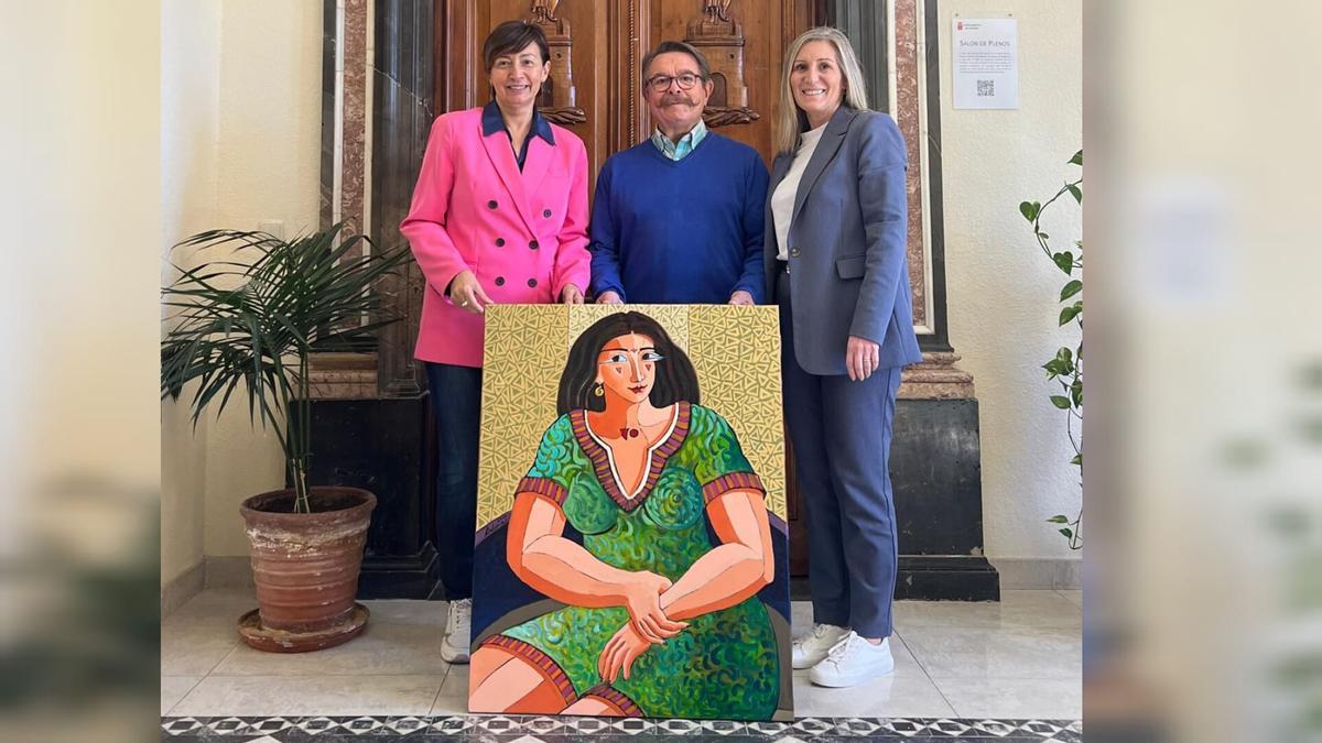 El pintor Luis Bolumar, la alcaldesa, Mª Carmen Climent; y la concejala Marisa López posan junto al cuadro.