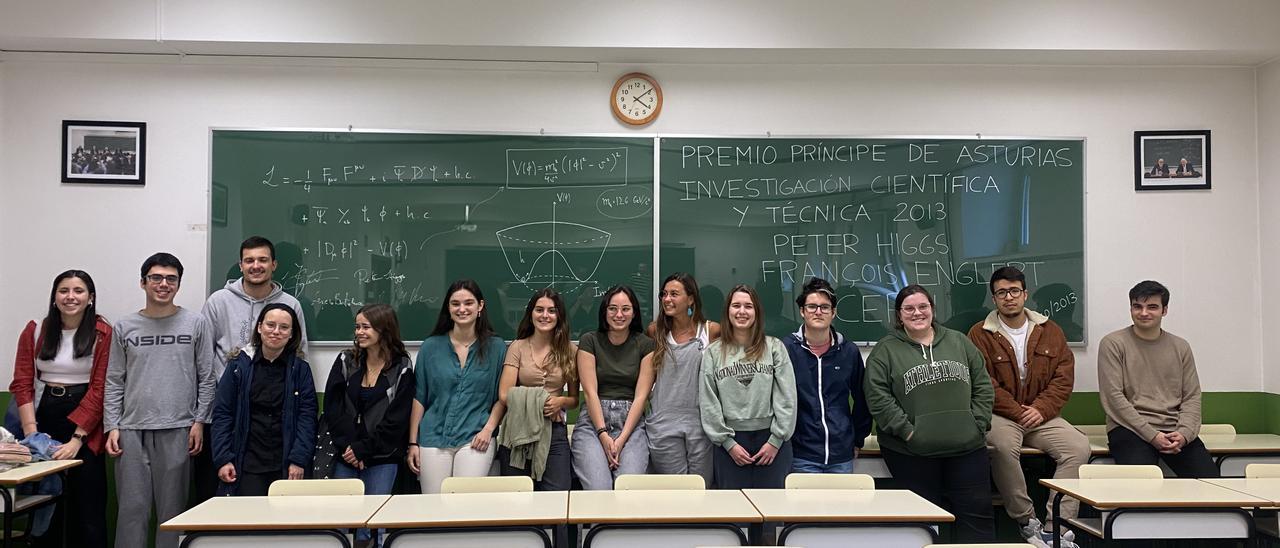 Alumnos de la facultad de Ciencias posan con la pizarra en la que está escrita la formulación del bosón de Higgs.