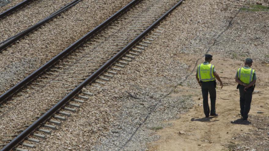 Dos guardias civiles inspeccionan la vía férrea en Alfafar.