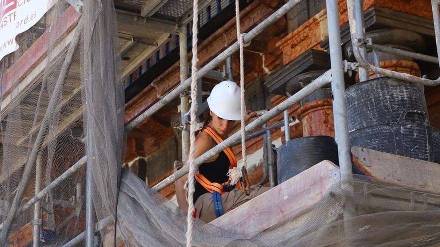 Una trabajadora en la rehabilitación de la fachada de un edificio de Córdoba.