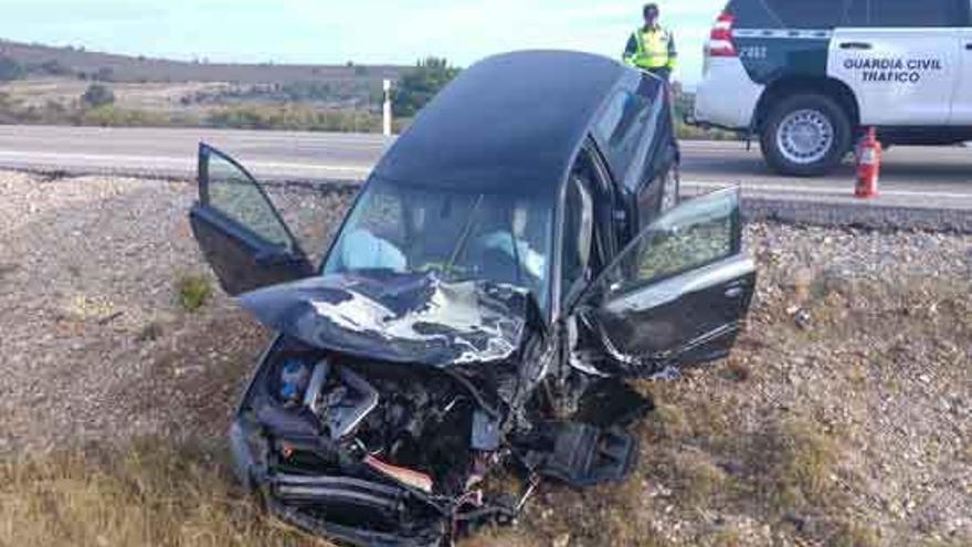 Un guardia civil observa uno de los vehículos implicados en el accidente.