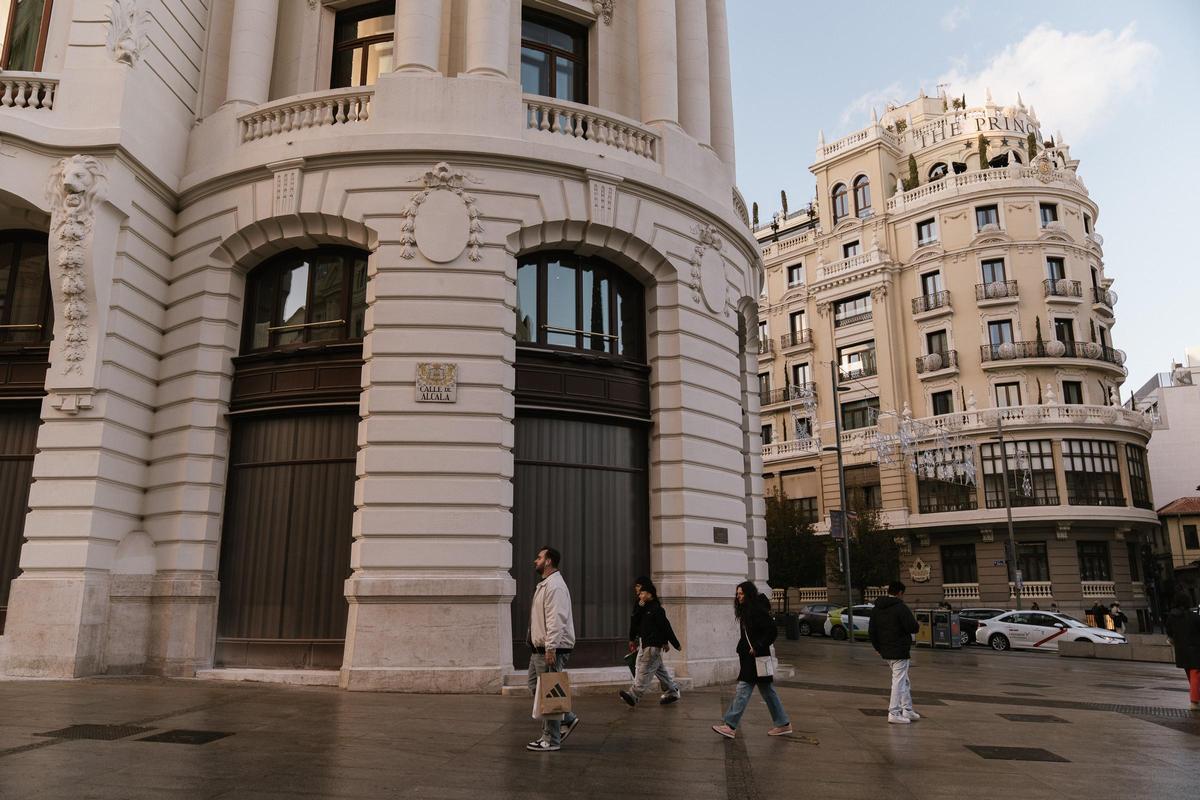 Los transeúntes pasean delante de la entrada del edificio, desprovista ya de vallas de obra.