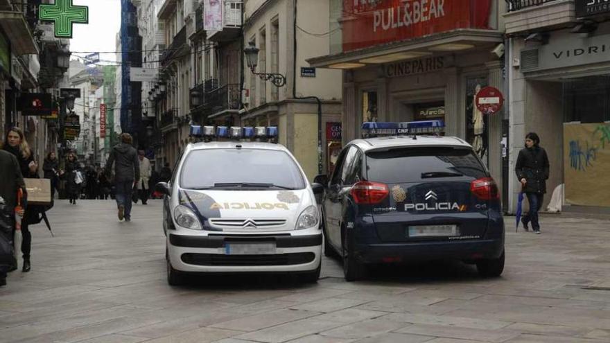 Dos coches patrulla de la Policía Nacional, en la calle Real.