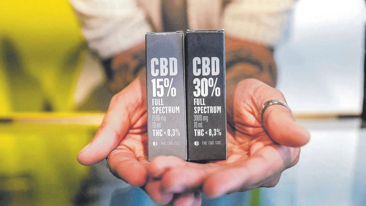 Un empleado de una ‘grow shop’ de Palma muestra algunos de los productos que contienen cannabidiol en diferentes proporciones.