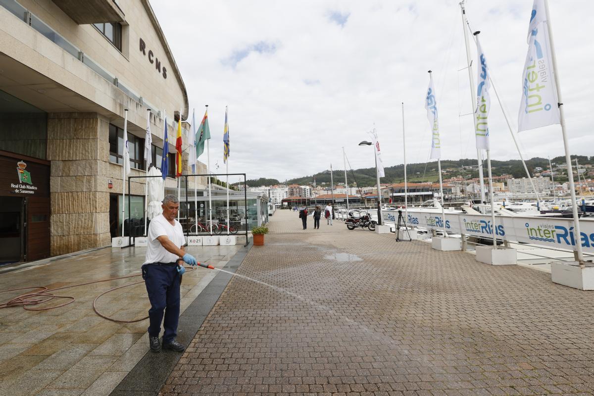 Un empleado del Real Club Náutico de Sanxenxo limpia al acceso a las instalaciones