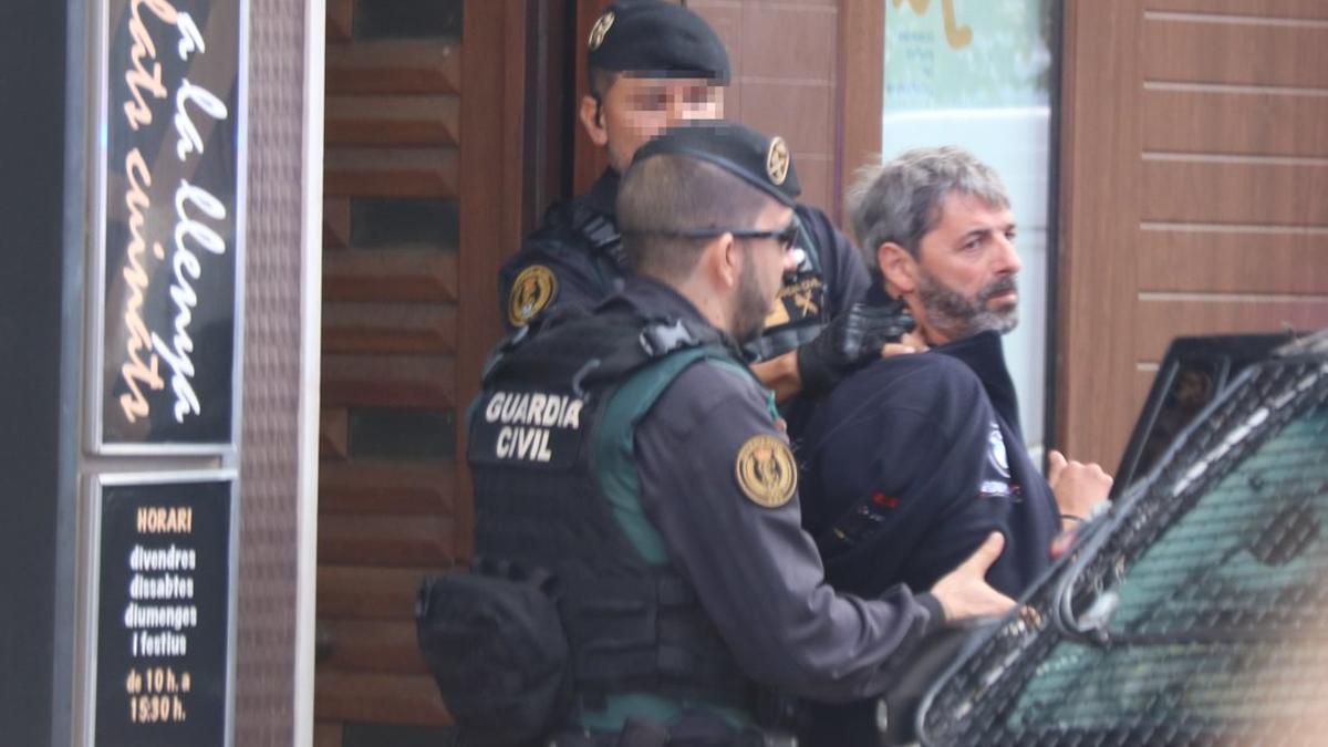 Dos agentes de la Guardia Civil llevan un detenido en Sabadell en el marco de la operación que ha acabado con nueve miembros de CDR arrestados.