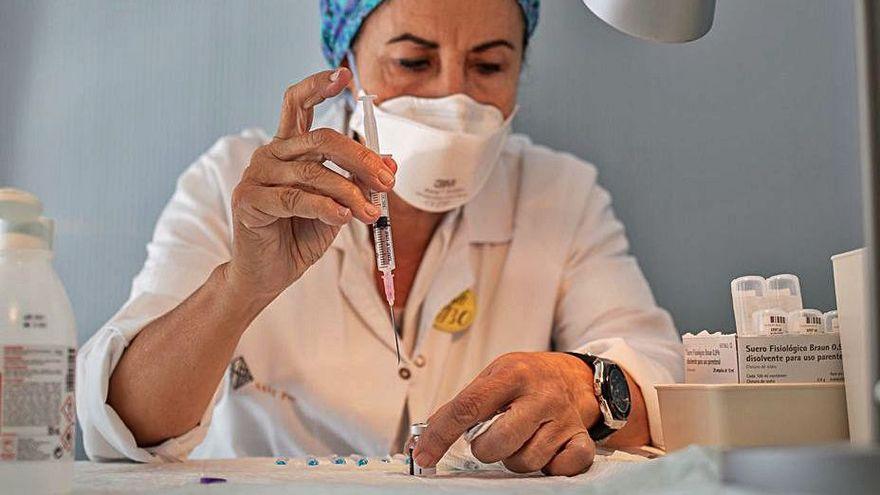 Una sanitaria preparando un vial de Pfizer.