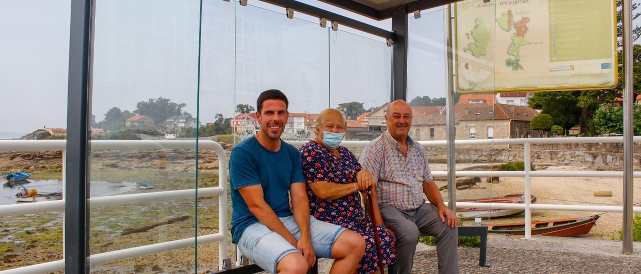 Luis Arosa (en primer término), ayer junto a dos vecinos en una de las nuevas marquesinas