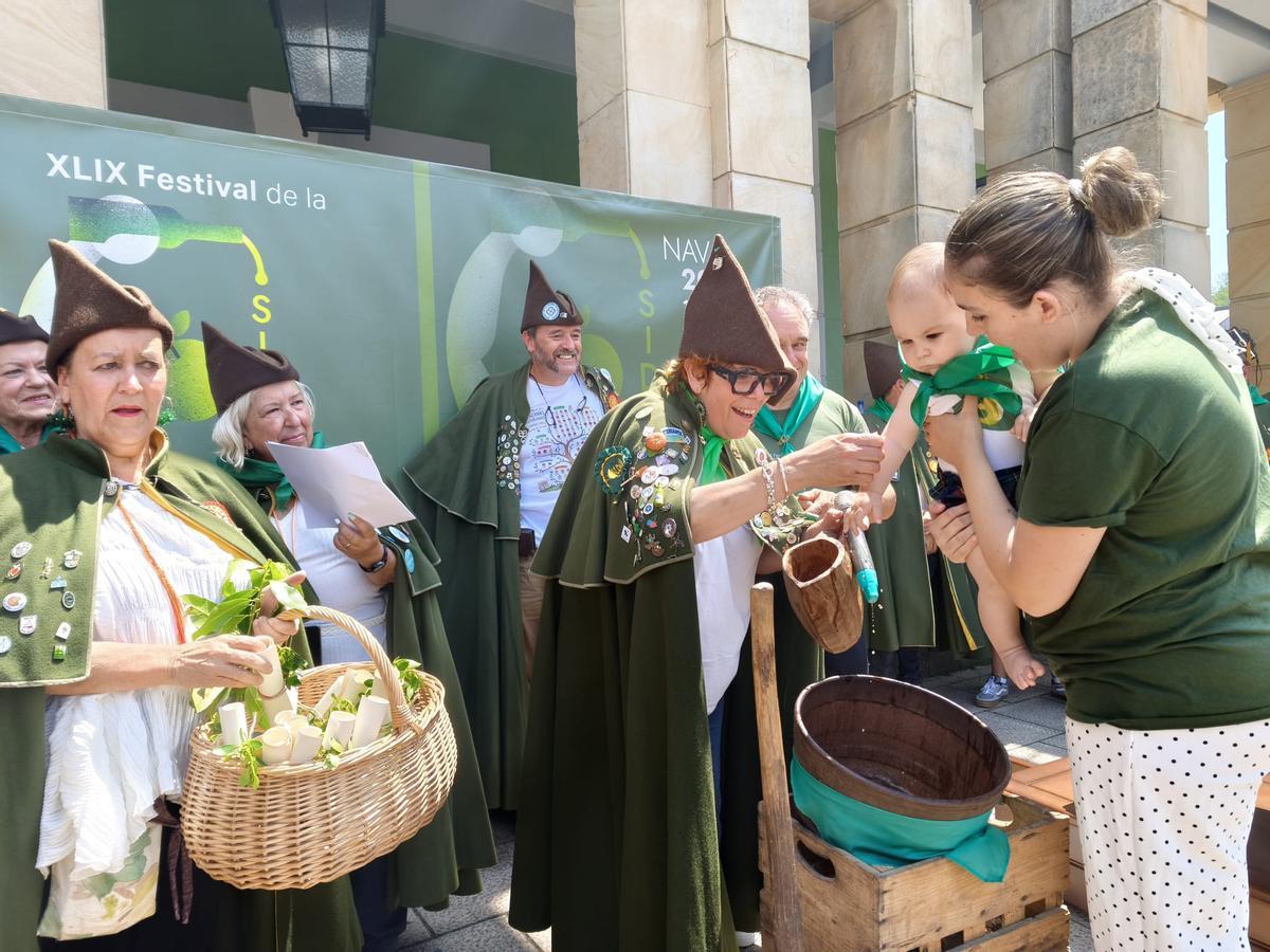 El bautismo sidrero de una veintena de bebés en el Festival de la Sidra de Nava, en imágenes