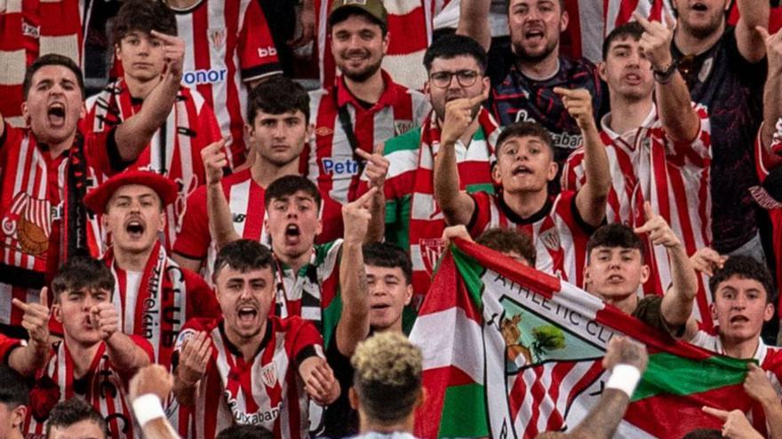 Hinchas insultan a un jugador rival en un estadio de fútbol.