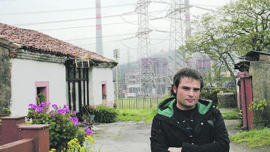 Pablo Quiroga, delante de unas casas en el barrio de Otero, apenas a dos metros de una subestación eléctrica, con la térmica al fondo.