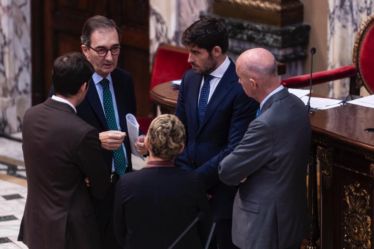 El secretario municipal hace un aparte con los portavoces