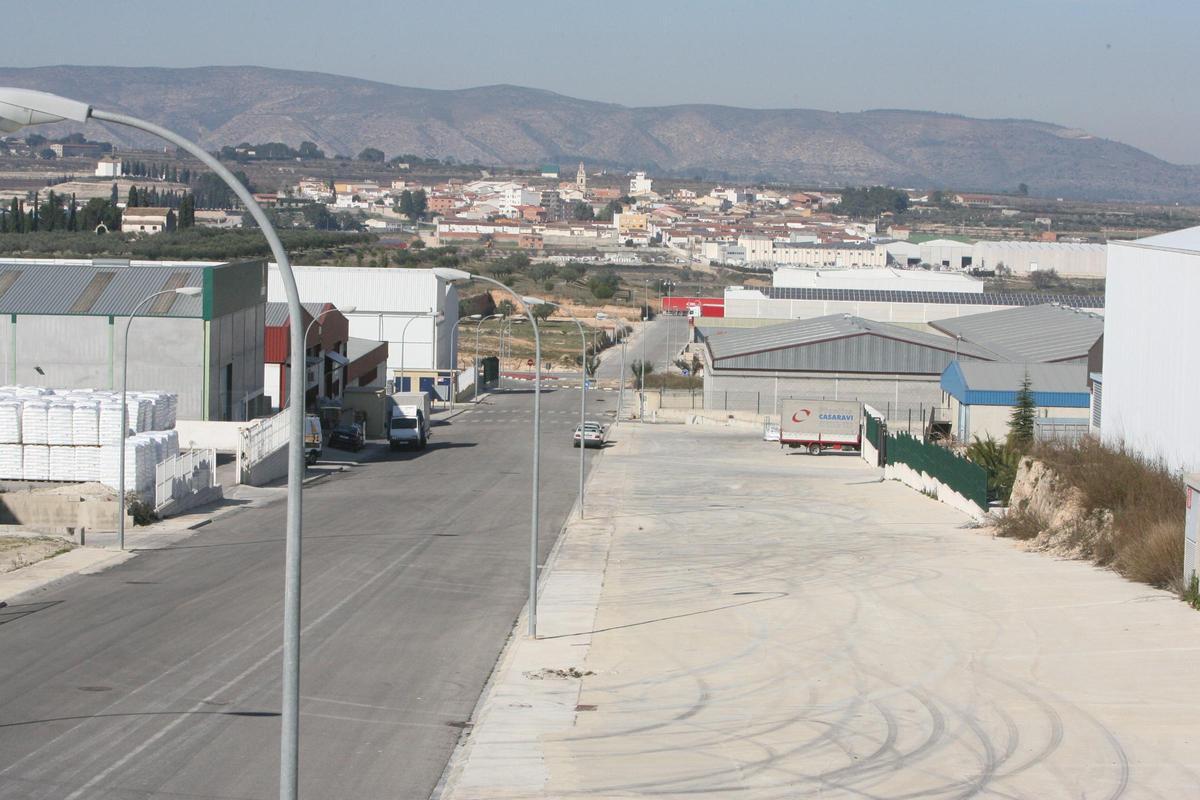 Naves en el polígono de Montaverner y, al fondo, el núcleo urbano de la población.