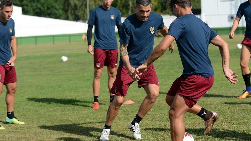 Álex Fernández y Mouriño se diputan un balón durante un entrenamiento en A Seca. // Rafa Vázquez