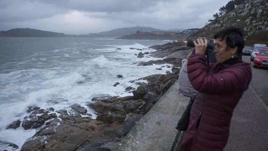 Una mujer observa el fuerte oleaje, ayer, en el litoral de Oia. // Ricardo Grobas