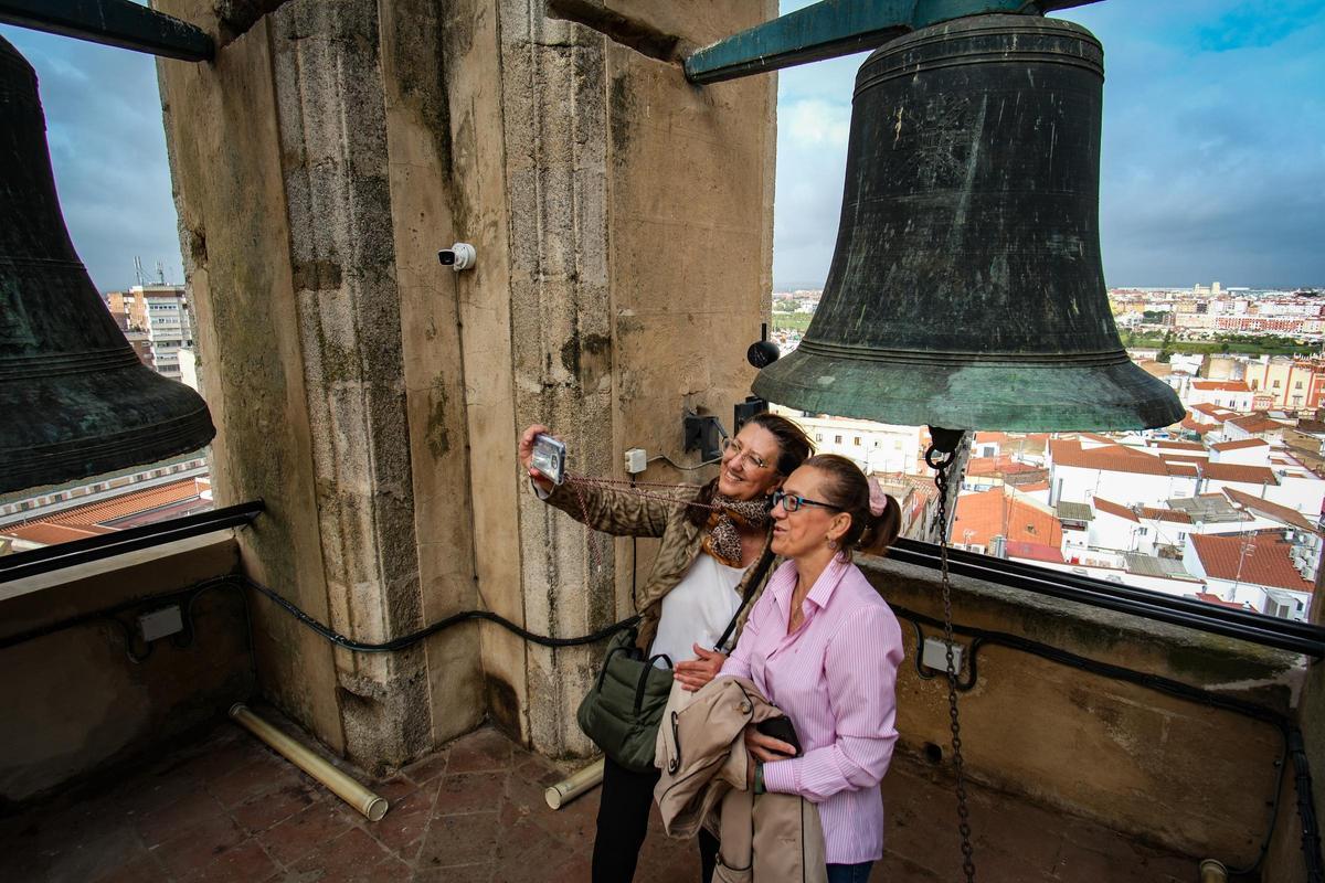 Mari Carmen y María José se hacen un selfi ante la campana Santa Cruz