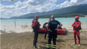 Un equipo de Bomberos de la DPH del parque de Sabiñánigo junto con bomberos de DPZ y de Navarra este mediodía en el embalse de Yesa.
